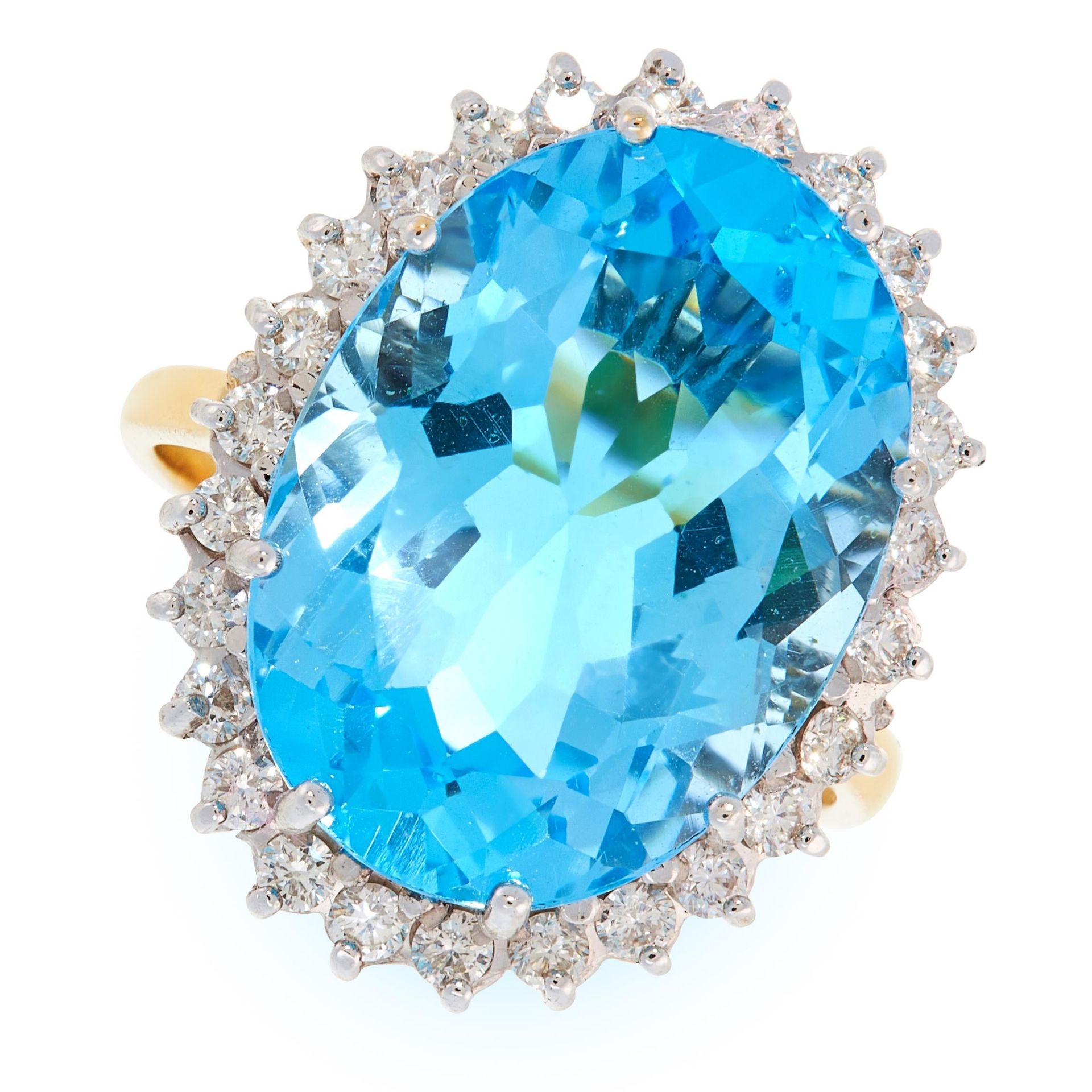 A BLUE TOPAZ AND DIAMOND CLUSTER RING in 18ct yellow gold, set with an oval cut topaz in a cluster