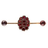 AN ANTIQUE GARNET BAR BROOCH in yellow gold, comprising of a gold bar set with a rose cut garnet