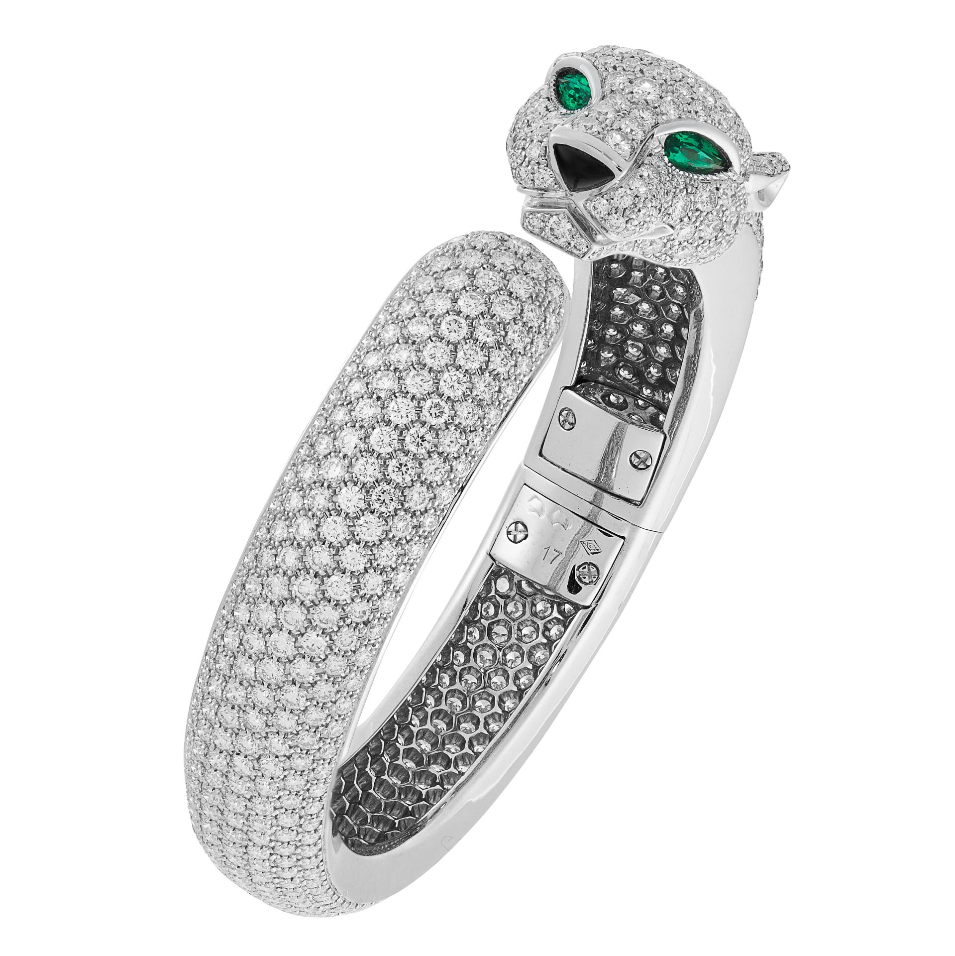 A DIAMOND AND EMERALD PANTHER BANGLE in 18ct white gold, designed as a coiling panther, set all over