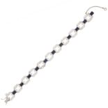A SAPPHIRE AND DIAMOND BRACELET, CIRCA 1940 in platinum, set with a single row of eleven step cut