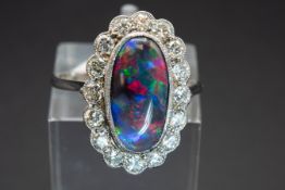 A PLATINUM, BLACK OPAL AND DIAMOND RING