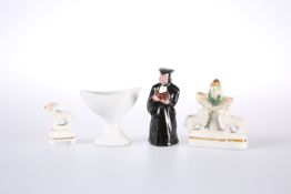 A 19TH CENTURY POTTERY FIGURAL CANDLE SNUFFER IN THE FORM OF A PRIEST,
