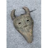 TRIBAL: A MASK, carved with horns and teeth. 30cm