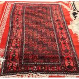 A BALOUCH RUG, with a red ground, circa 1940. 205cm by 105cm
