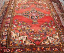 A MALAYER CARPET, the central medallion picked out in bright colours