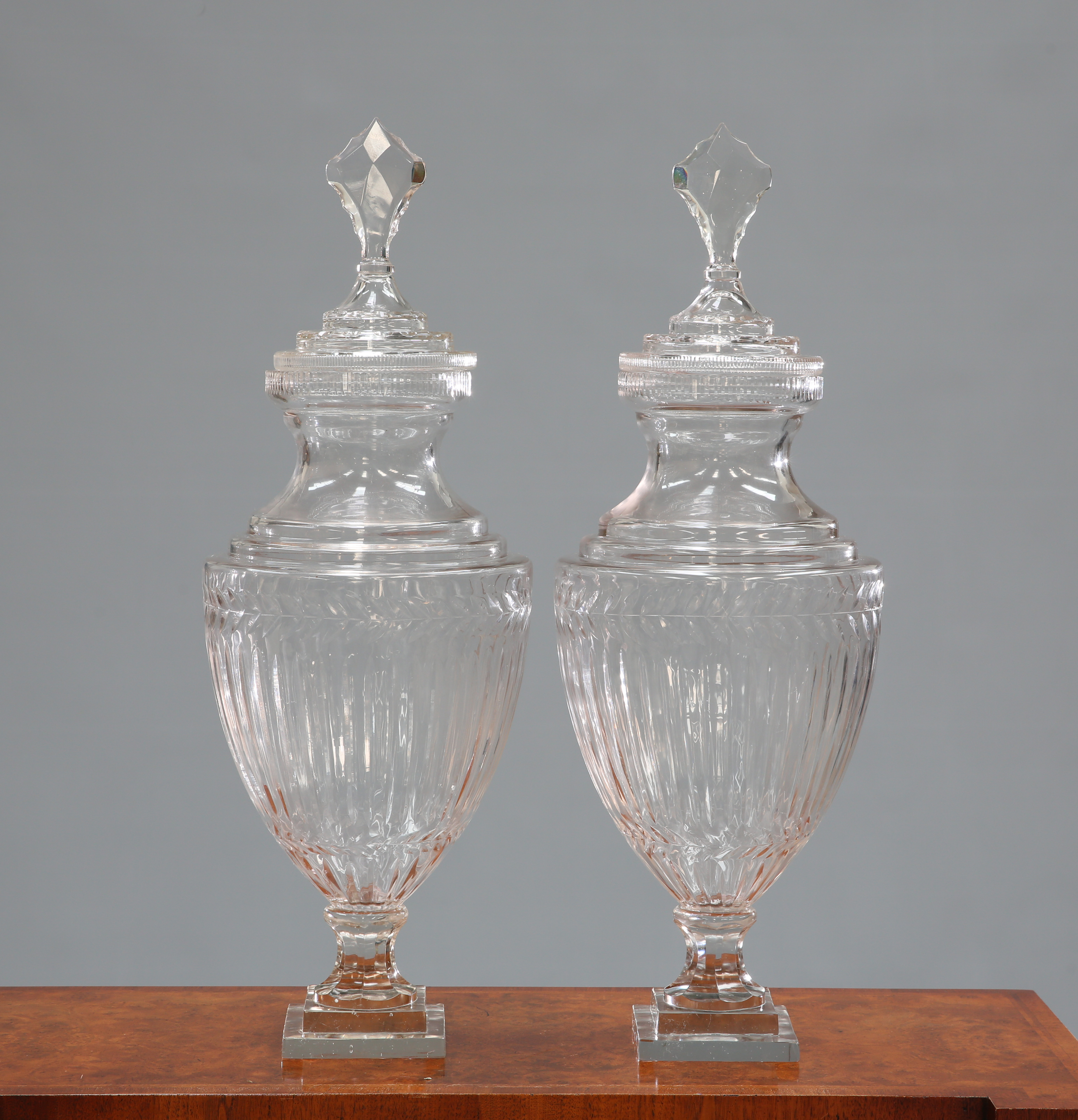 A LARGE PAIR OF ADAM STYLE GLASS URNS AND COVERS