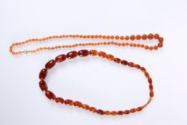 TWO STRINGS OF AMBER COLOURED BEAD NECKLACES