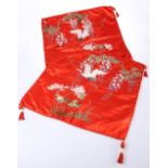 A PAIR OF EARLY 20TH CENTURY CHINESE RED GROUND EMBROIDERED SILK PANELS OR COVERS