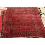 A BALOUCH RUG, with four centre reserves and a red ground, circa 1950