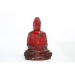 A CHINESE MODEL OF A SEATED BUDDHA, POSSIBLY CHERRY AMBER