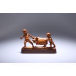 A JAPANESE CARVED WOODEN OKIMONO OF CHILDREN PLAYING WITH A PIG