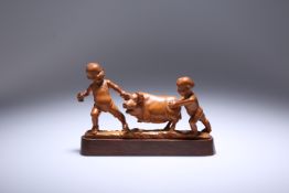 A JAPANESE CARVED WOODEN OKIMONO OF CHILDREN PLAYING WITH A PIG