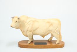 A BESWICK MODEL OF A CHAROLAIS BULL, on wooden plinth. 20cm high