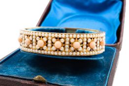 A LATE 19TH CENTURY CORAL AND HALF PEARL BANGLE