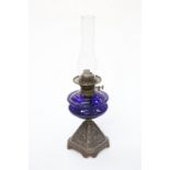 A QUEEN VICTORIA BLUE GLASS AND CAST IRON OIL LAMP