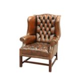 A HANDSOME DEEP-BUTTONED BROWN LEATHER WING CHAIR