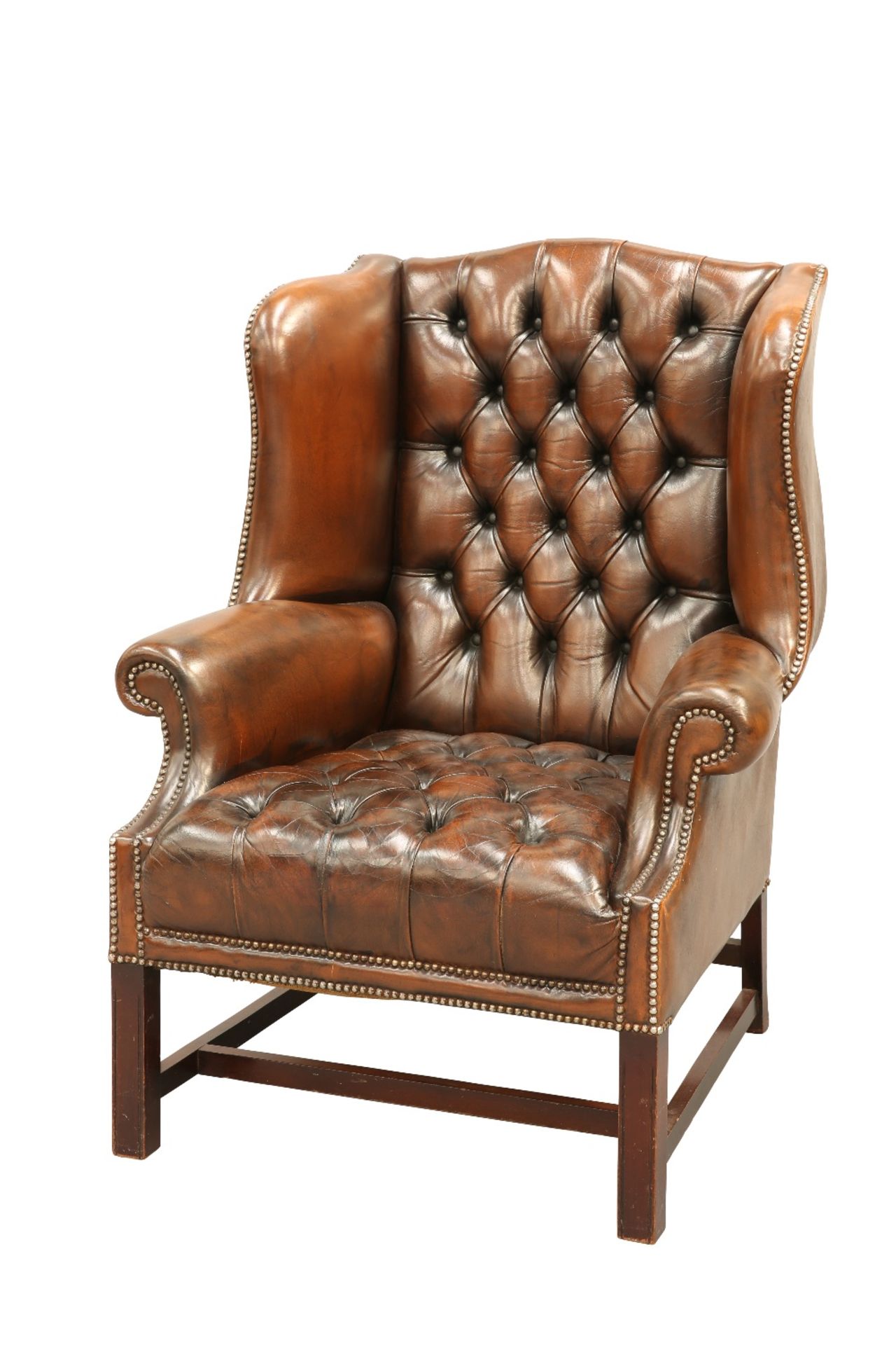 A HANDSOME DEEP-BUTTONED BROWN LEATHER WING CHAIR