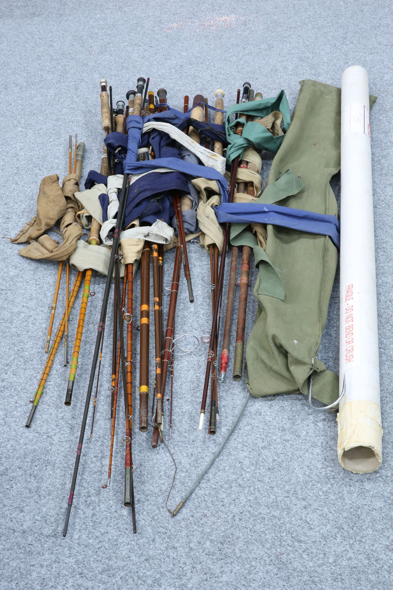 A COLLECTION OF OLD FISHING RODS AND OTHER TACKLE ITEMS