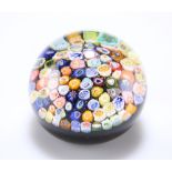 A CLOSE-PACK MILLEFIORI GLASS PAPERWEIGHT