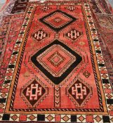 A KASHGAR CARPET, with two primary medallions and six smaller to a red ground