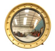 A LARGE REGENCY GILT-COMPOSITION CONVEX MIRROR