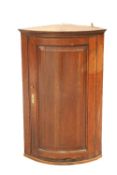 A GEORGE III OAK BOW-FRONT HANGING CORNER CUPBOARD