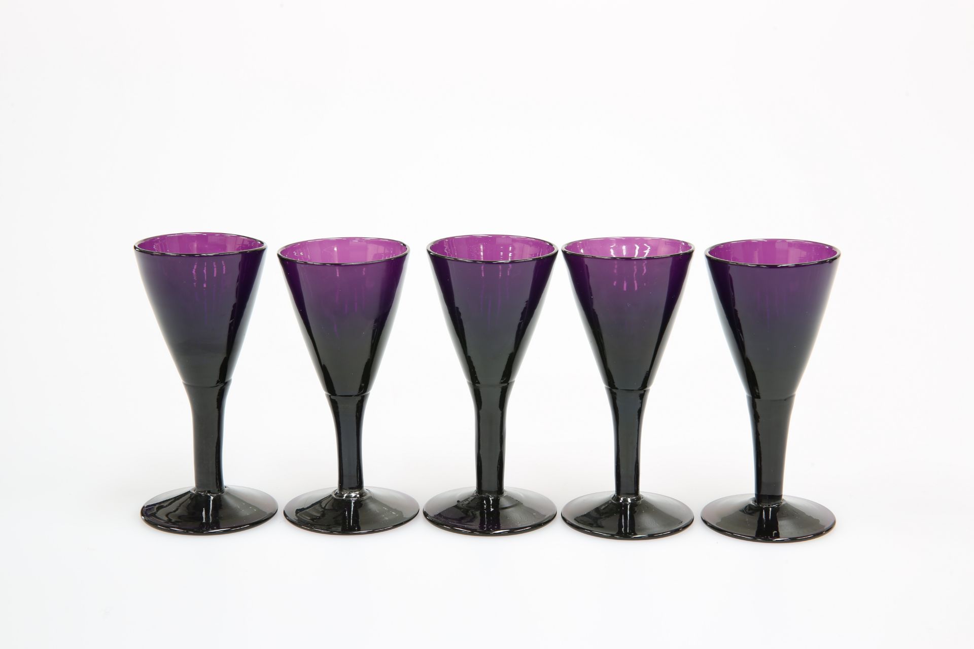 A SET OF FIVE AMETHYST GLASS PORT OR SHERRY GLASSES, SECOND QUARTER 19th CENTURY