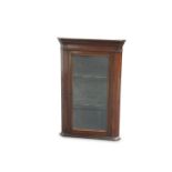 A SMALL GLAZED MAHOGANY CORNER CUPBOARD