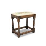 A 17TH CENTURY STYLE OAK STOOL WITH NEEDLEWORK SEAT