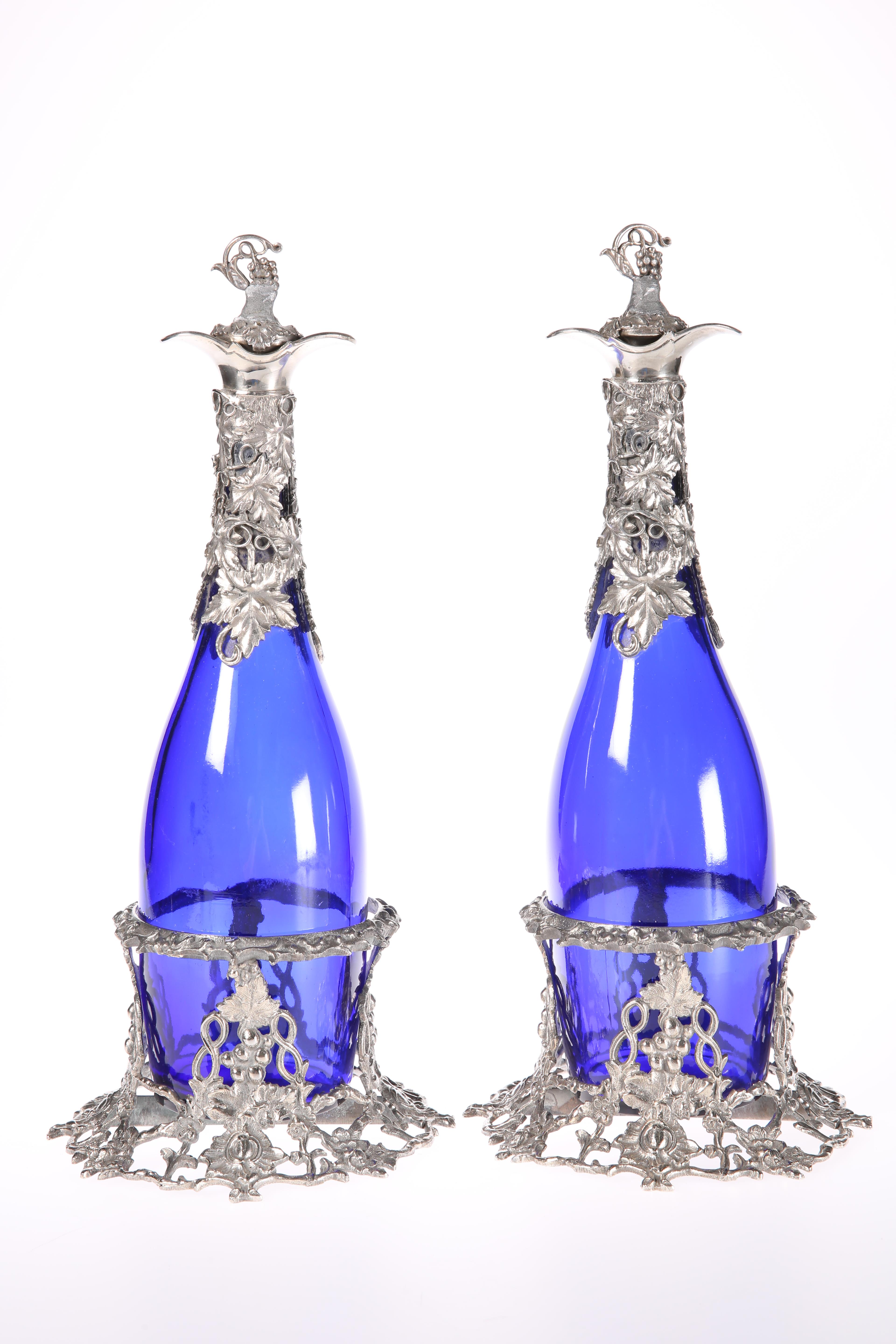 A PAIR OF SILVER=PLATE MOUNTED BLUE-GLASS DECANTERS