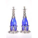 A PAIR OF SILVER=PLATE MOUNTED BLUE-GLASS DECANTERS