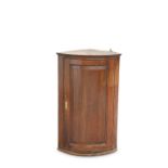 A GEORGE III OAK BOW-FRONT HANGING CORNER CUPBOARD