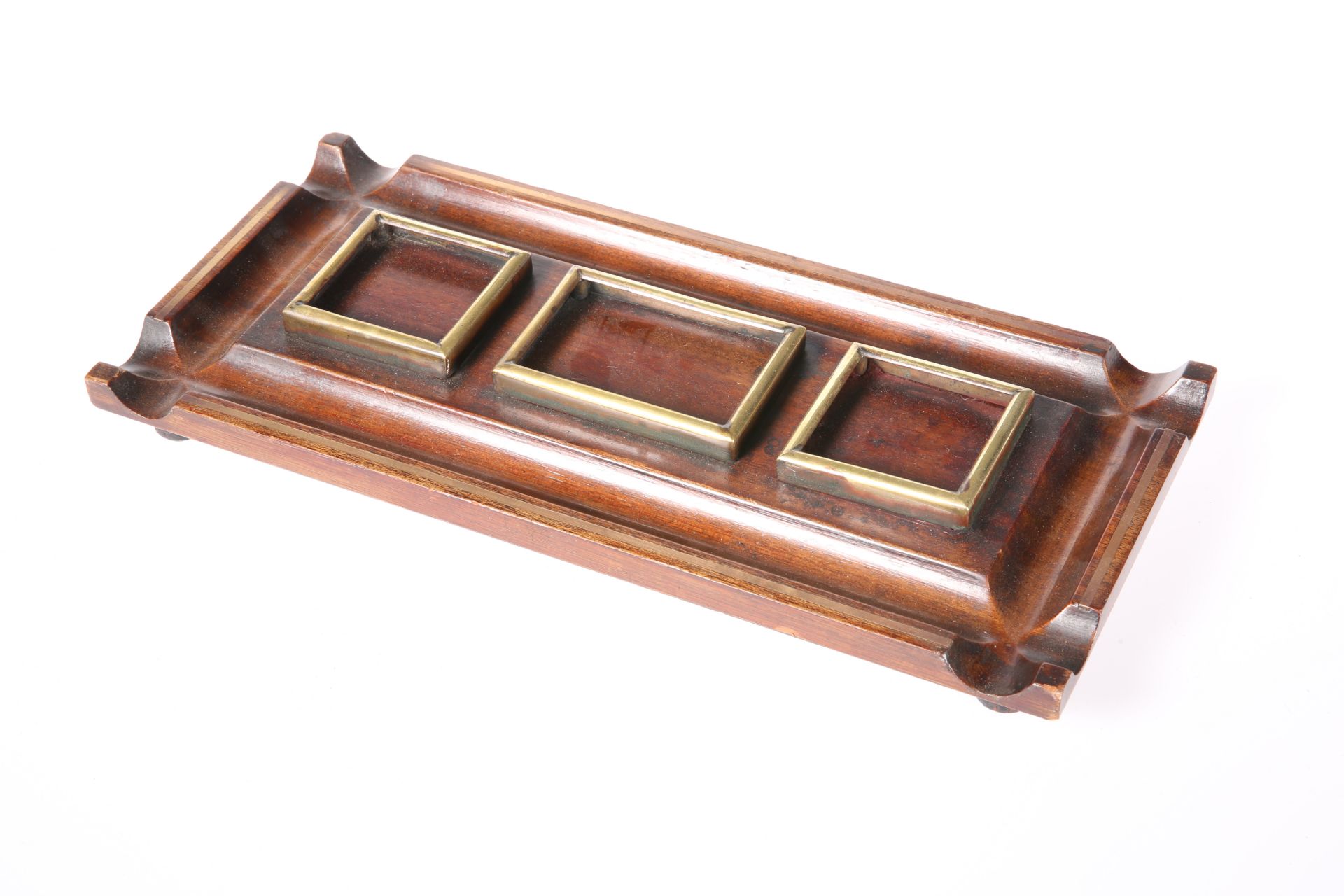 A REGENCY BRASS AND MAHOGANY INKSTAND, rectangular, lacking bottles.