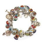A STERLING SILVER CHARM BRACELET, charms predominantly crested
