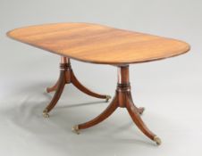 A MAHOGANY TWIN-PEDESTAL DINING TABLE, IN REGENCY STYLE