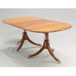 A MAHOGANY TWIN-PEDESTAL DINING TABLE, IN REGENCY STYLE