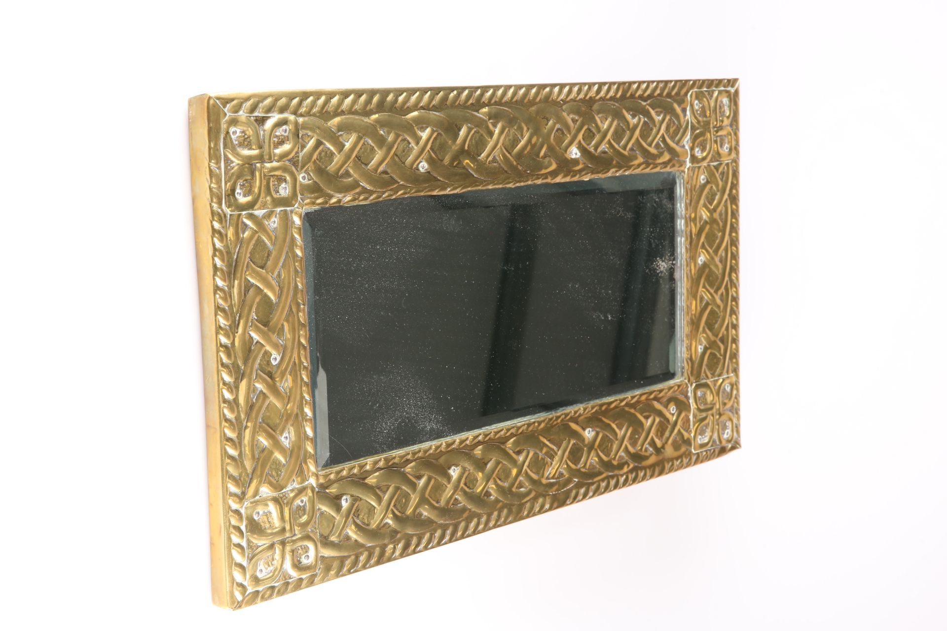 AN ARTS AND CRAFTS BRASS MIRROR