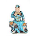 A CHINESE SANCAI GLAZED FIGURE OF A GUARDIAN, LATE MING DYNASTY