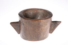 AN EARLY CARVED TWO-HANDLED WOODEN MORTAR