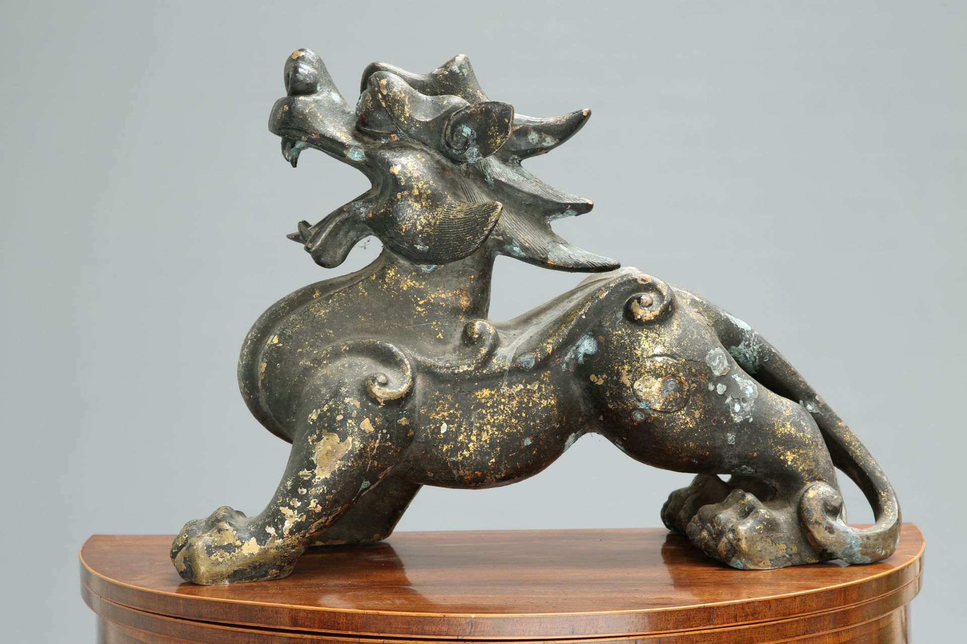A LARGE CHINESE GILDED METAL MODEL OF A FU DOG