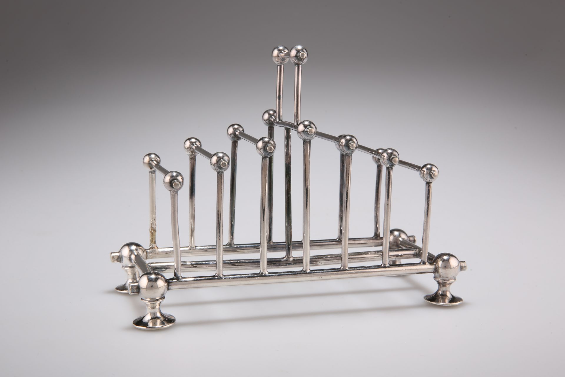 AN AESTHETIC SILVER-PLATED TOAST RACK, IN THE STYLE OF CHRISTOPHER DRESSER