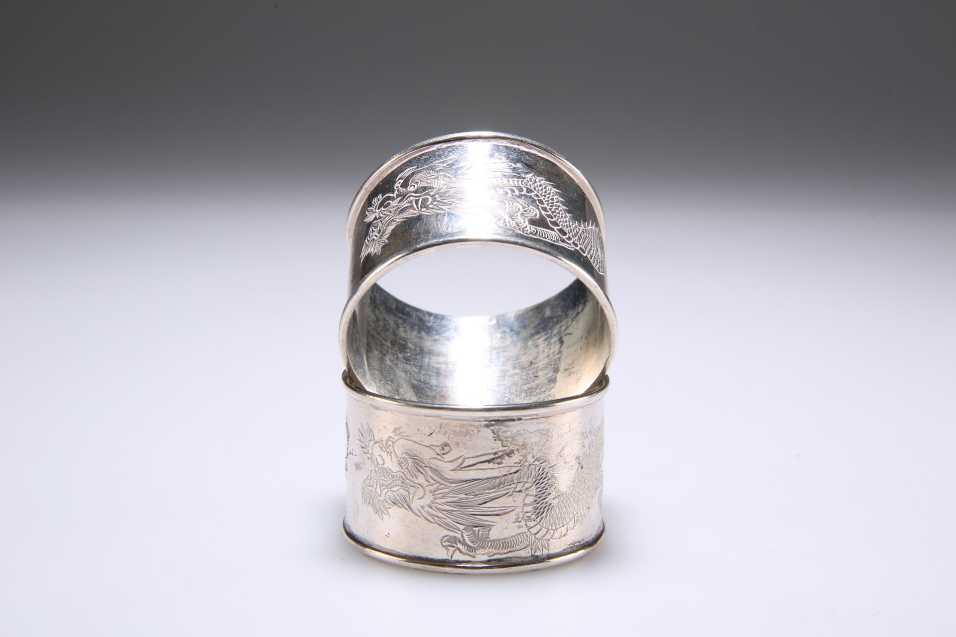TWO CHINESE SILVER NAPKIN RINGS, of circular form, the central band engraved with a dragon, bears - Image 2 of 2