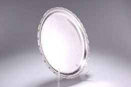 A RARE OMAR RAMSDEN SILVER SALVER, London 1932, of circular form with dentilled border, planished