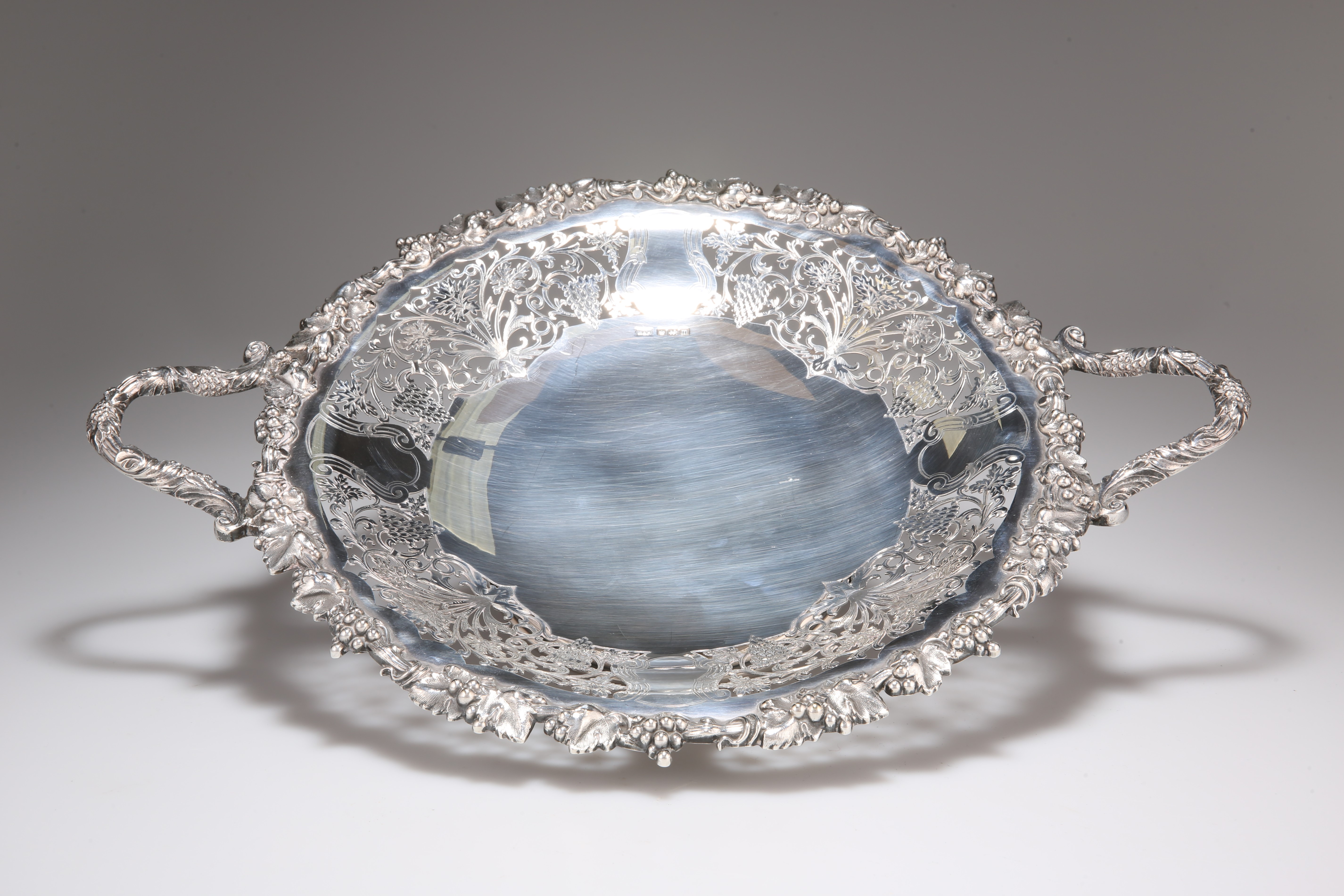 A GEORGE V SILVER TWIN HANDLED CAKE STAND, by Walker and Hall, Sheffield 1929, of circular form