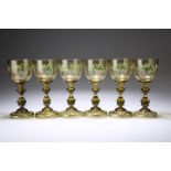 SIX 19TH CENTURY BOHEMIAN GREEN GLASS WINES, the bowls enamel painted with fruiting vine and