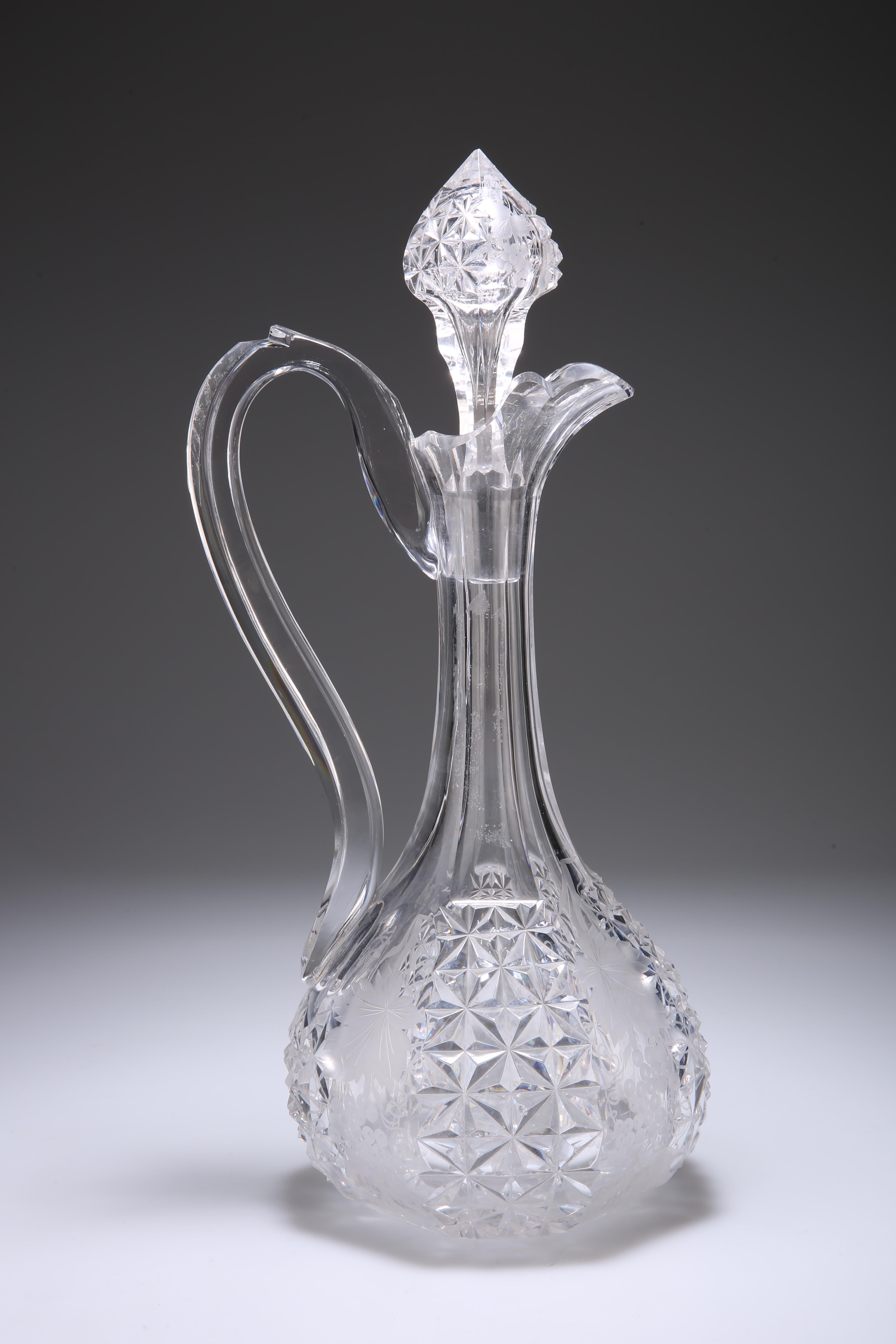 A LATE 19TH CENTURY CUT-GLASS CLARET JUG, the bulbous base issuing a faceted slender neck housing