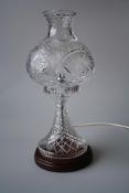 A 20TH CENTURY CUT-GLASS TABLE LAMP, with globular detachable shade and tapering stem, raised on a