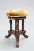 A VICTORIAN MAHOGANY ADJUSTABLE PIANO STOOL with circular buttoned seat