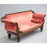 A WILLIAM IV MAHOGANY SETTEE, with leaf carving to the back and scrolling arms, raised on carved