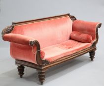 A WILLIAM IV MAHOGANY SETTEE, with leaf carving to the back and scrolling arms, raised on carved